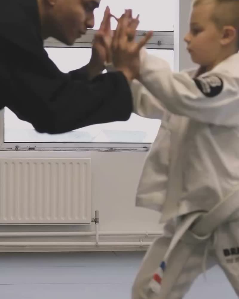 A coach and a young student on the mat
