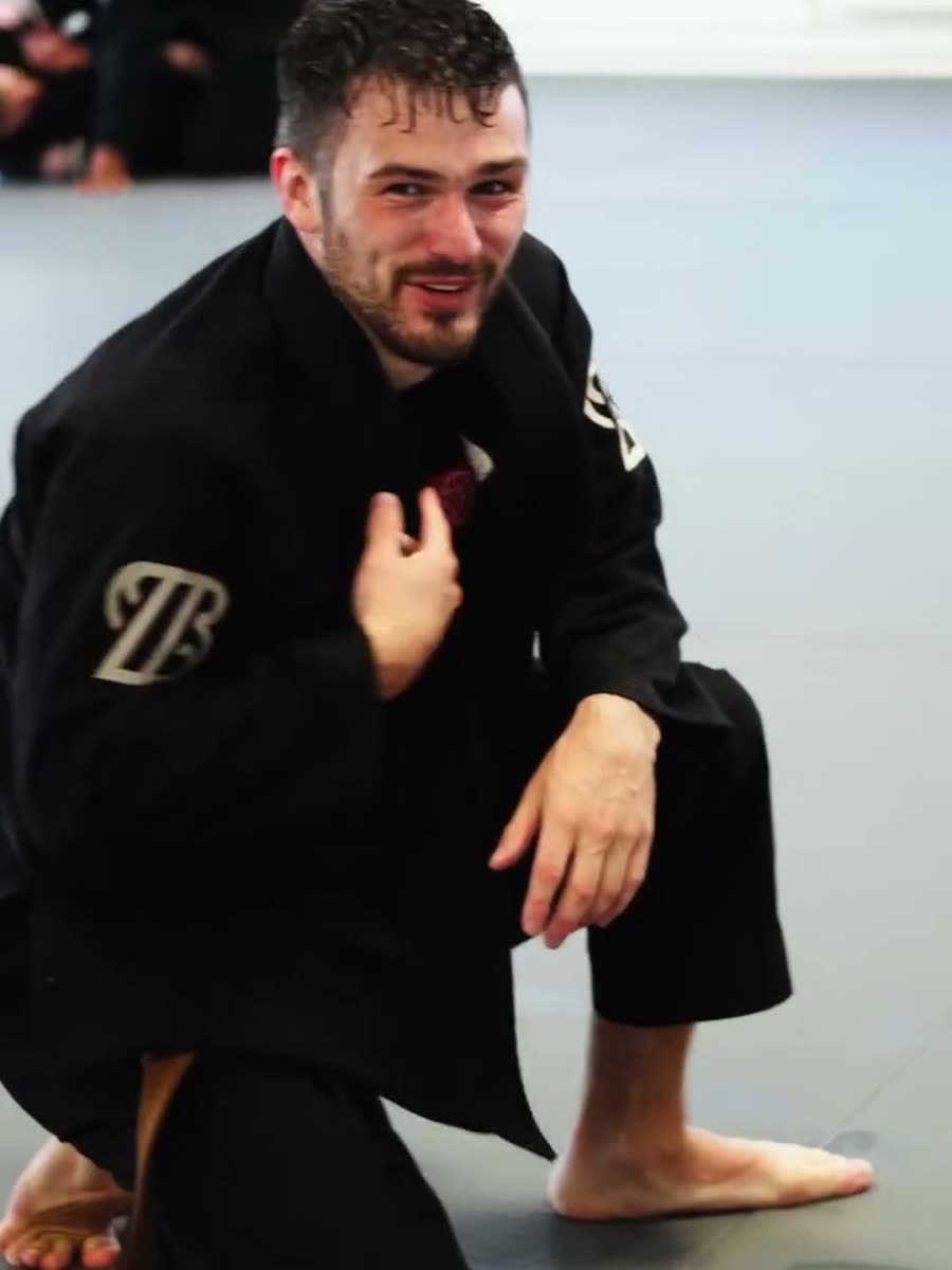 A coach on the mats between rounds at Brazier Jiu Jitsu Academy